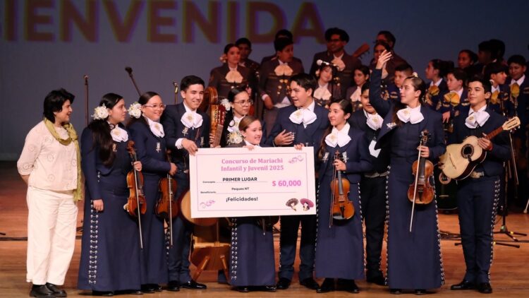 Un grupo de mariachis jóvenes sonríe en un escenario mientras sostiene un cheque grande de premio.