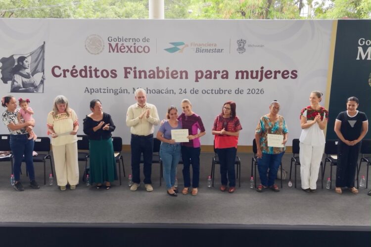 Un grupo de personas está en un escenario entregando certificados durante un evento titulado “Créditos Finabien para mujeres” en Apatzingán, Michoacán.