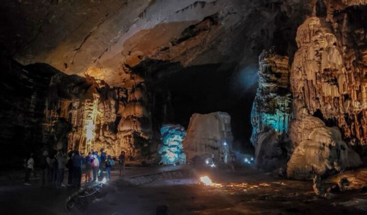 Visitantes recorren las grutas de Cacahuamilpa iluminadas durante un paseo cultural del INAH.