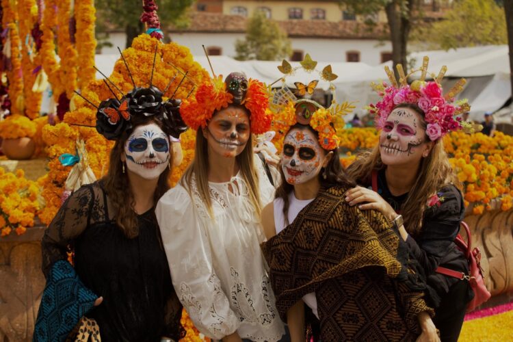 Mujeres con maquillaje de calaveras celebran la Noche de Muertos en Michoacán