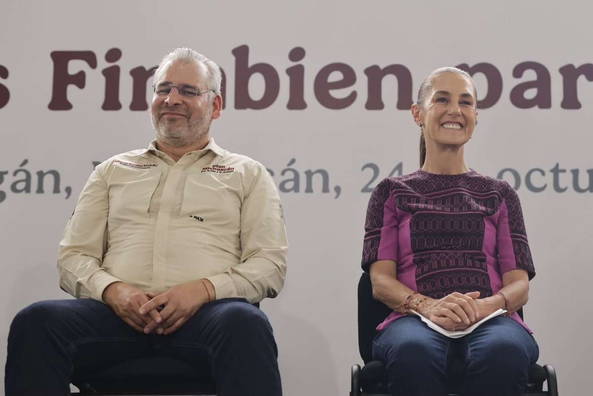 Claudia Sheinbaum y Alfredo Ramírez Bedolla sonríen durante entrega de créditos Finabien en Apatzingán.