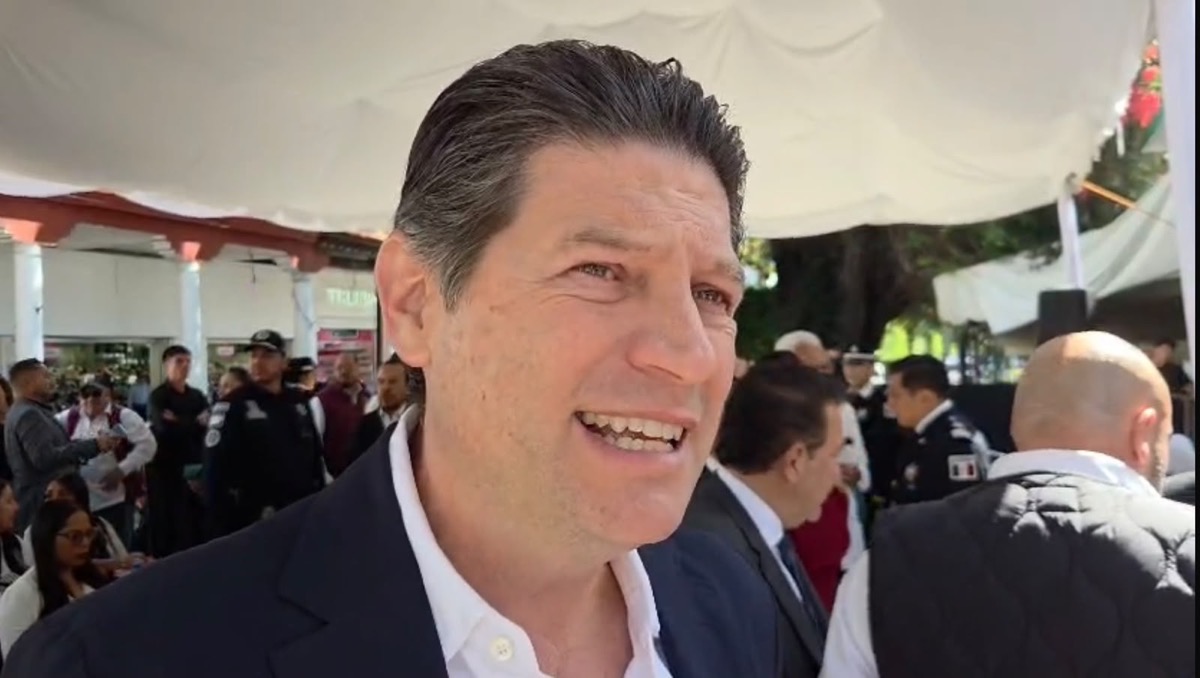 Alfonso Martínez Alcázar sonríe durante un evento en Uruapan rodeado de asistentes y autoridades.