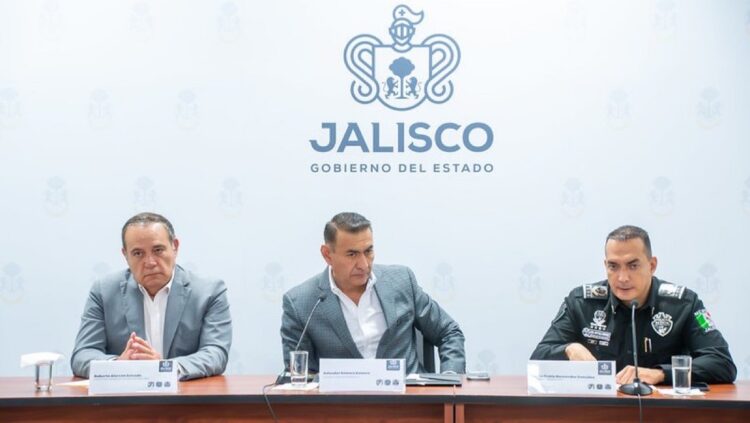 Tres hombres sentados en una mesa durante una conferencia de prensa del gobierno del estado de Jalisco.