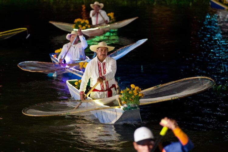 Canoas con flores de cempasúchil navegan de noche en los canales de Urandén durante la Noche de Muertos.