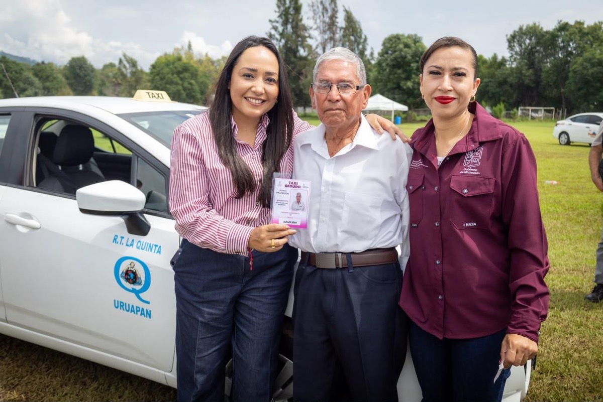 Funcionarios entregan credencial de Taxi Seguro frente a un taxi blanco en Uruapan.